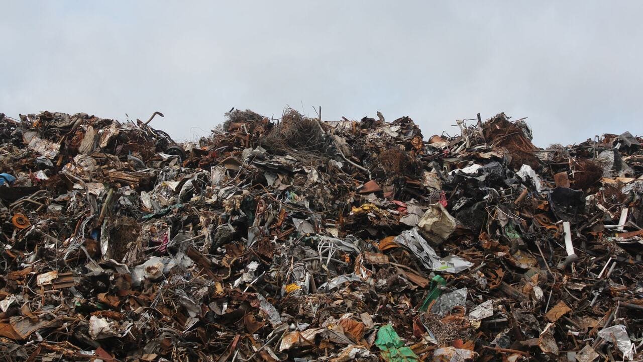 a mountain of of solid waste including packaging, textiles, and discarded goods