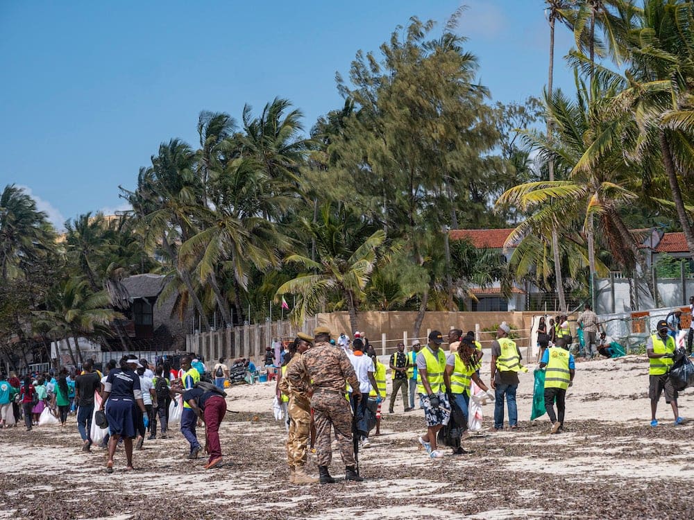 Participants actively collecting and removing debris from Mombasa's coastline, showcasing the teamwork involved in the International Coastal Cleanup event.